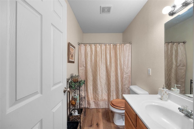 bathroom featuring hardwood / wood-style floors, vanity, toilet, and walk in shower