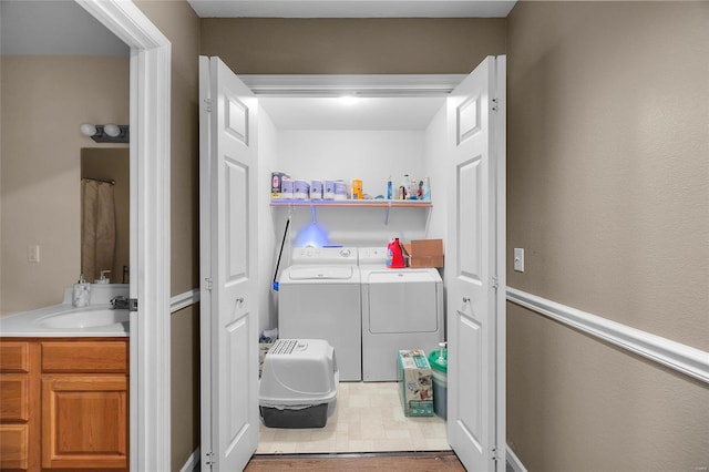 clothes washing area featuring washer and dryer, tile patterned floors, and sink