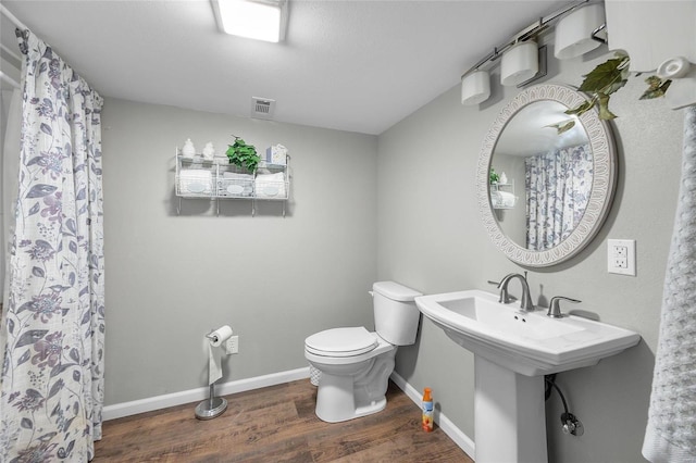 bathroom with hardwood / wood-style flooring and toilet