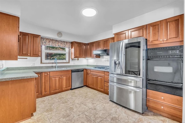 kitchen featuring sink, stainless steel appliances, and decorative backsplash