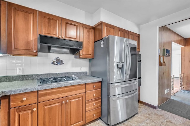 kitchen with light stone counters, stainless steel appliances, and tasteful backsplash