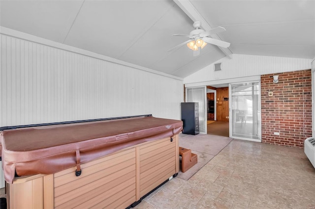 miscellaneous room featuring ceiling fan, brick wall, vaulted ceiling with beams, and wood walls