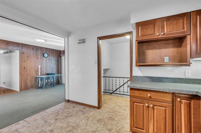 kitchen with wooden walls and light carpet