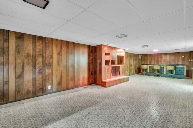 basement featuring carpet flooring and wooden walls