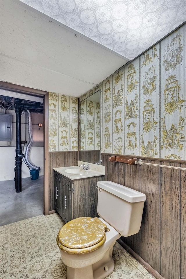 bathroom with vanity, toilet, electric panel, and concrete flooring