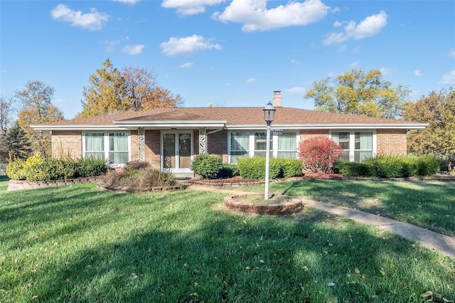 ranch-style home featuring a front yard, brick siding, and a chimney