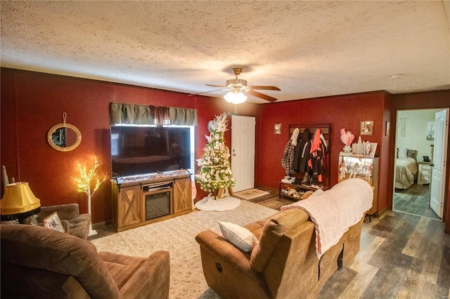 living room with a textured ceiling, dark hardwood / wood-style flooring, and ceiling fan