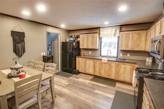 kitchen featuring sink, light brown cabinets, light hardwood / wood-style floors, a textured ceiling, and black appliances