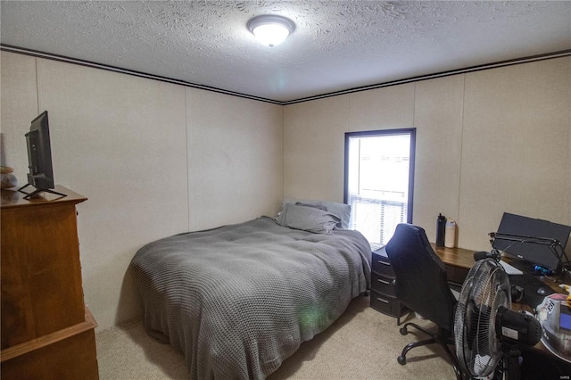 bedroom with a textured ceiling and light carpet