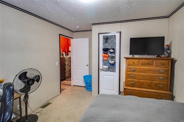 carpeted bedroom featuring a textured ceiling and ornamental molding