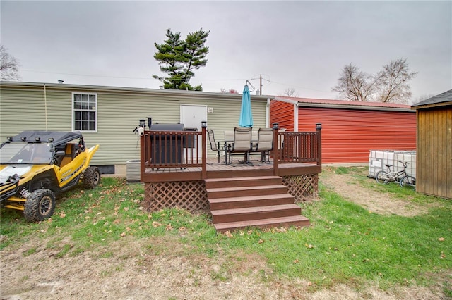 rear view of house with a lawn and a wooden deck