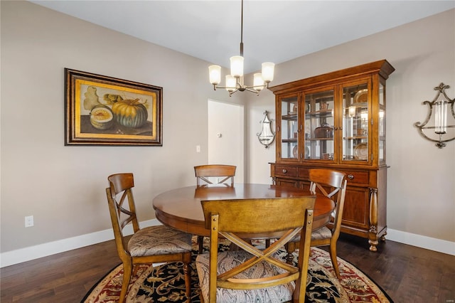 dining area with dark wood-type flooring and a notable chandelier