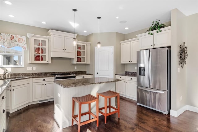 kitchen with sink, hanging light fixtures, dark hardwood / wood-style flooring, a kitchen island, and appliances with stainless steel finishes