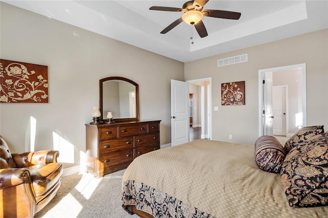 bedroom featuring ceiling fan, a raised ceiling, and carpet floors