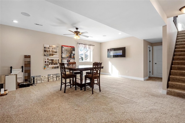 dining space featuring light colored carpet and ceiling fan