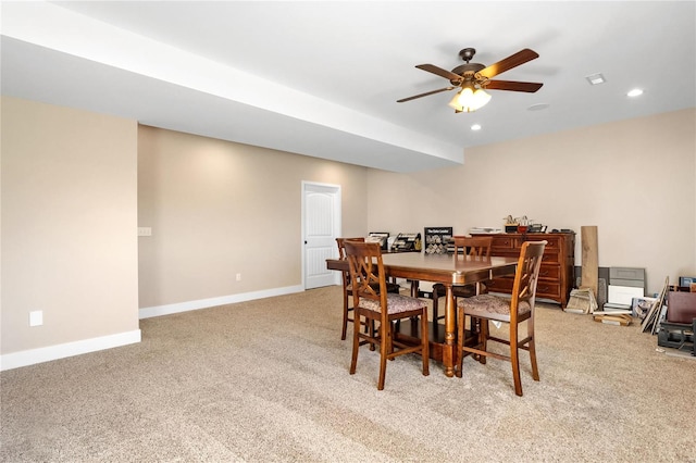 carpeted dining area with ceiling fan