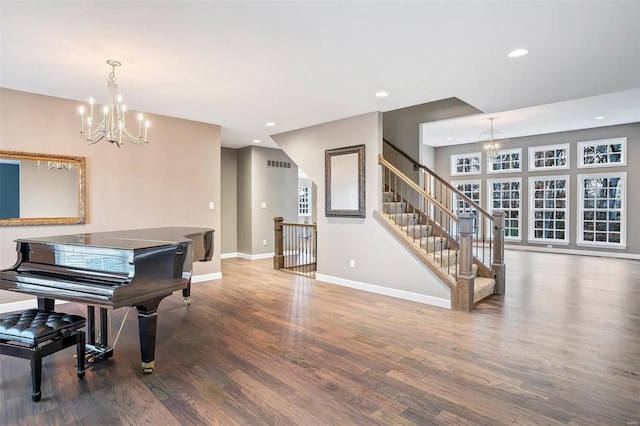 miscellaneous room featuring wood-type flooring and a notable chandelier