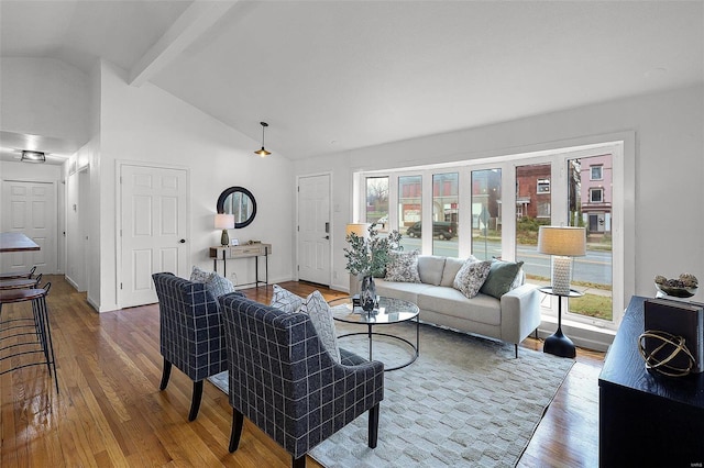 living room with vaulted ceiling with beams and hardwood / wood-style floors