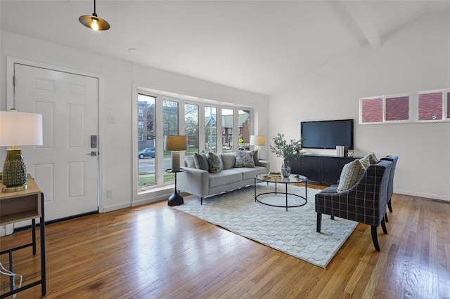 living room with hardwood / wood-style floors and lofted ceiling with beams