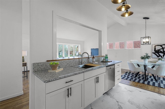 kitchen with light stone countertops, stainless steel dishwasher, sink, white cabinets, and vaulted ceiling with beams