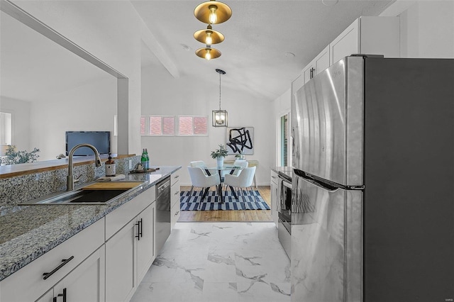 kitchen with lofted ceiling, white cabinets, sink, appliances with stainless steel finishes, and stone countertops