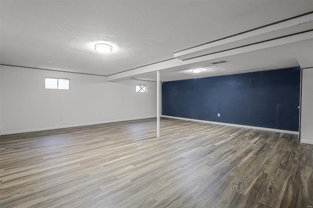 basement with wood-type flooring and a textured ceiling