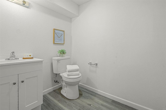 bathroom featuring vanity, hardwood / wood-style flooring, and toilet