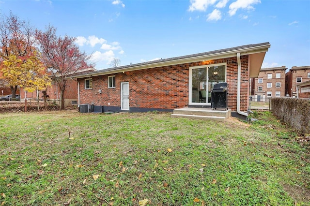 rear view of property with a yard and central AC unit