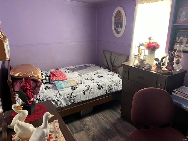 bedroom featuring crown molding and dark wood-type flooring