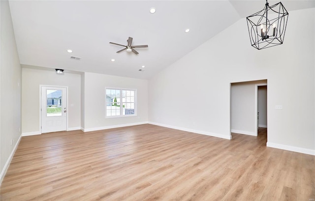 unfurnished living room featuring high vaulted ceiling, light hardwood / wood-style floors, and ceiling fan with notable chandelier