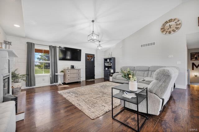 living room featuring high vaulted ceiling and dark wood-type flooring