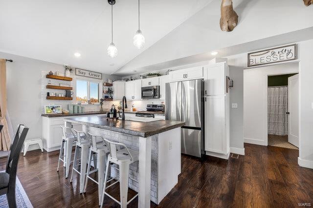 kitchen with white cabinets, pendant lighting, dark wood-type flooring, and appliances with stainless steel finishes