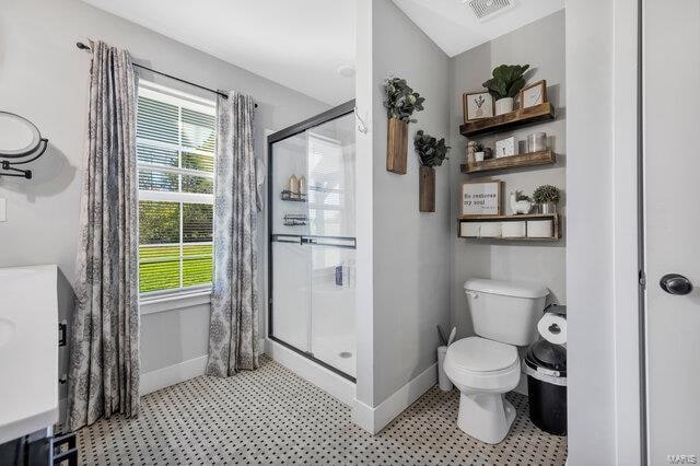 bathroom with toilet and a shower with door