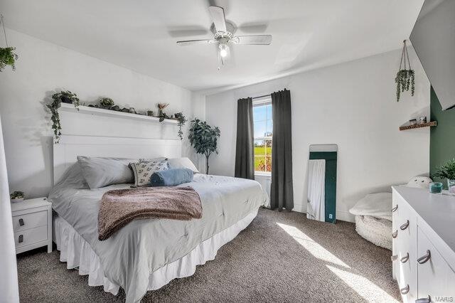 bedroom with ceiling fan and dark carpet