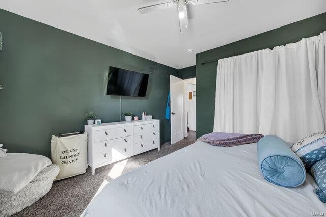 bedroom with ceiling fan and dark carpet