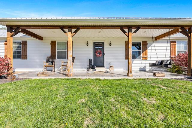 single story home with covered porch and a front lawn