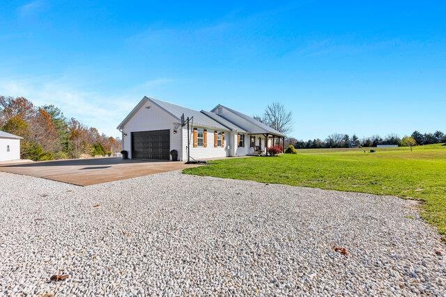 ranch-style house featuring a front lawn and a garage