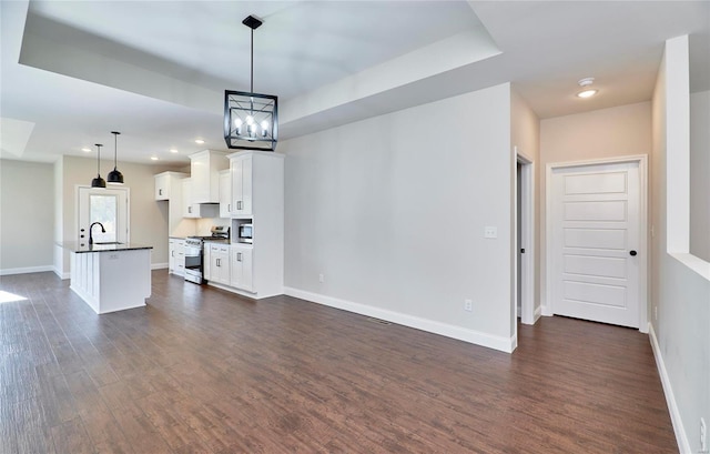 unfurnished living room featuring sink, dark hardwood / wood-style floors, and a notable chandelier