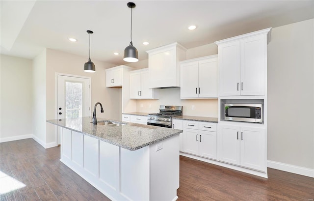 kitchen featuring light stone countertops, stainless steel appliances, white cabinetry, and sink