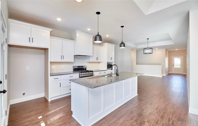 kitchen featuring white cabinetry, stainless steel gas range oven, and a kitchen island with sink