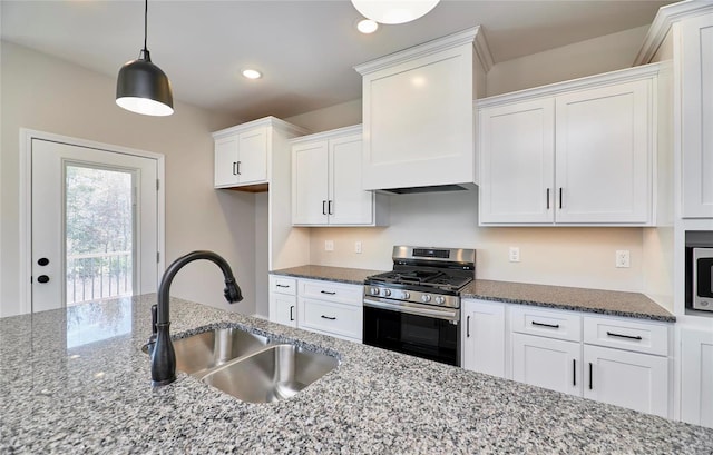 kitchen featuring appliances with stainless steel finishes, decorative light fixtures, white cabinetry, and sink