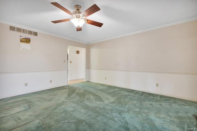 spare room featuring carpet floors and crown molding