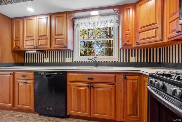 kitchen featuring stainless steel gas stove, sink, and black dishwasher