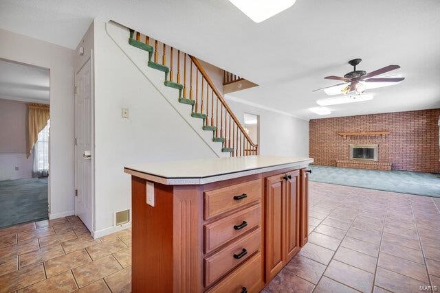 kitchen with ceiling fan, a fireplace, and a center island