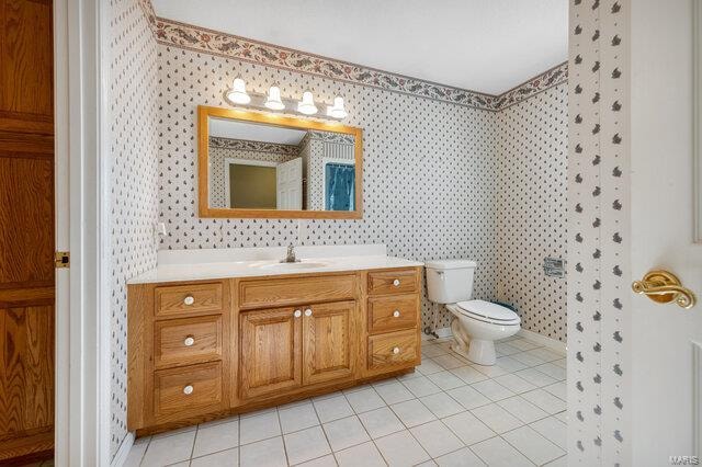 bathroom featuring tile patterned floors, vanity, and toilet