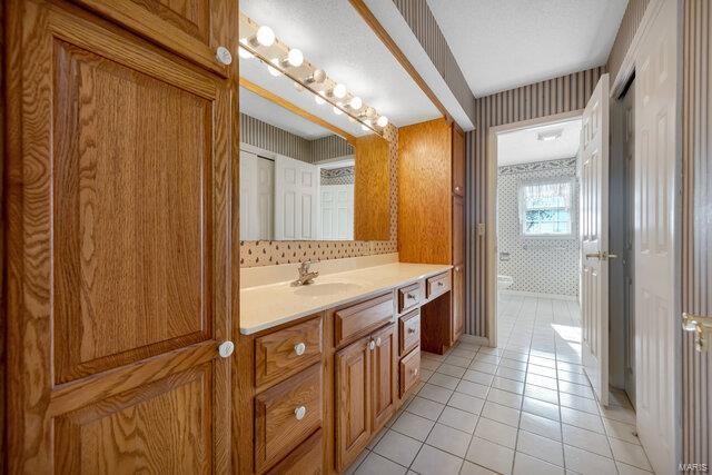 bathroom with tile patterned flooring, vanity, and toilet