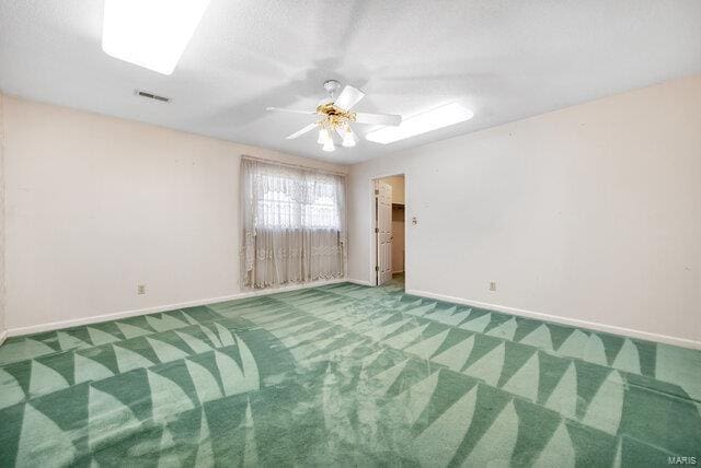 carpeted spare room with ceiling fan