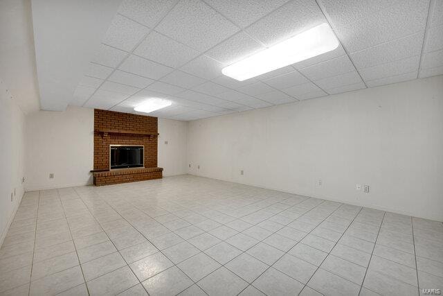 unfurnished living room with a paneled ceiling and a fireplace