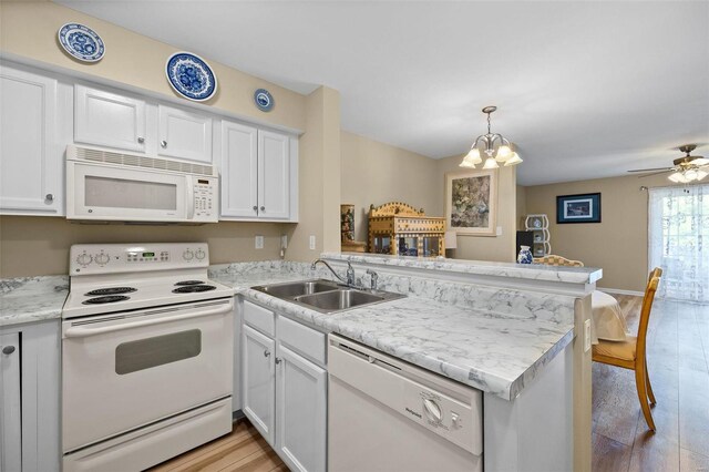 kitchen featuring kitchen peninsula, sink, white appliances, and light wood-type flooring