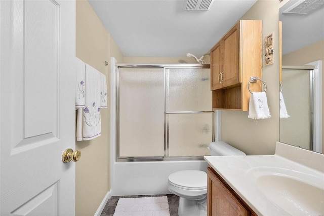 full bathroom with tile patterned flooring, vanity, bath / shower combo with glass door, and toilet